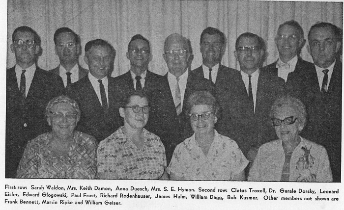 Black and white photograph of group of trustees from Sandusky County, Ohio, with nine men standing in back row and four women seated in front row, circa 1960s