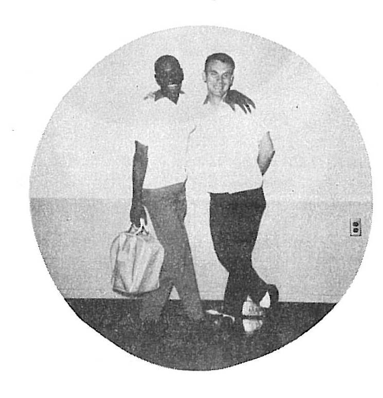 Two men in white shirts and dark pants standing together, one holding a briefcase, black and white circular photograph