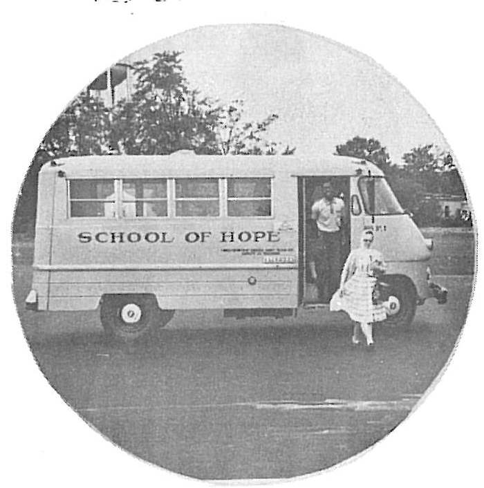 Vintage mobile school bus labeled "School of Hope" with a young girl standing at the entrance door, representing early educational services in Ohio